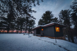 Cozy cabin in Pipestem Resort State Park on a winter evening.