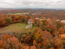 Aerial view of the Bolar Lookout Tower amid Pipestem Resort State Park during the fall.