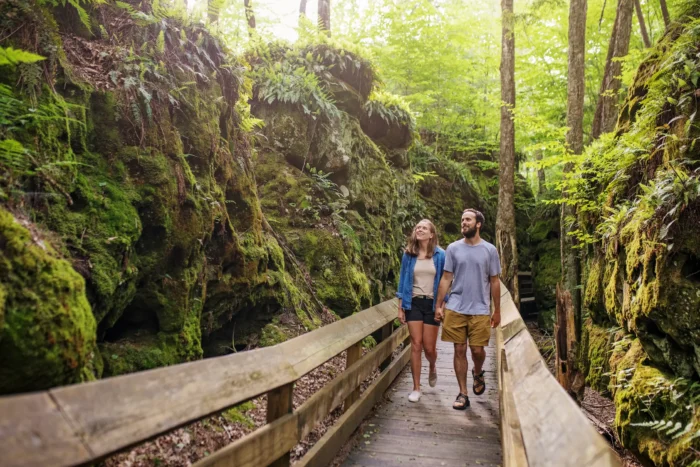 A couple holding hands and walking along the boardwalk at Breatown State Park.