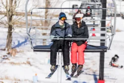 Two people sitting on a ski lift at Canaan Valley Resort State Park.