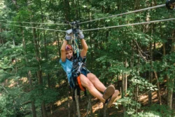 Young adventurist enjoying the zip-line experience during the summer offered in Pipestem Resort State Park.