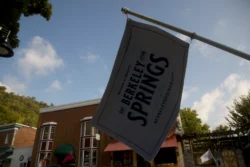 Close-up of a Berkeley Springs Flag hanging in front of the street during the summer.