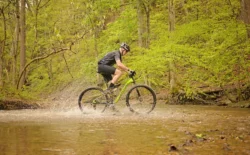 Biker splashing through Davis Creek in Kanawha State Forest during the summer.