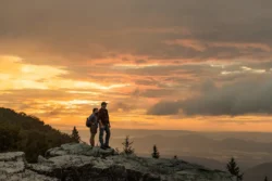 Couple reaches an overlook point at sunset on their hike through Monongahela National Forest.