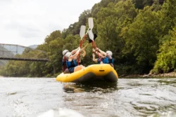 Team of outdoor enthusiasts celebrating their rafting experience on the Greenbrier River during the summer.
