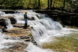 Fisherman fishing by the waterfall at Camp Creek State Park and Forest