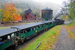 Uphill view of passengers riding aboard the vintage locomotive of Cass Scenic Railroad in the fall.