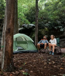 Couple enjoying coffee outside their camping tent