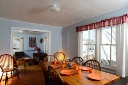 A dining room with a table and chairs inside a company house.
