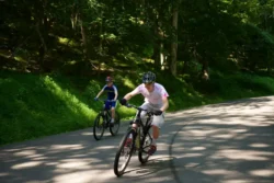 Two young bikers riding along the North Bend Rail Trail during the summer.