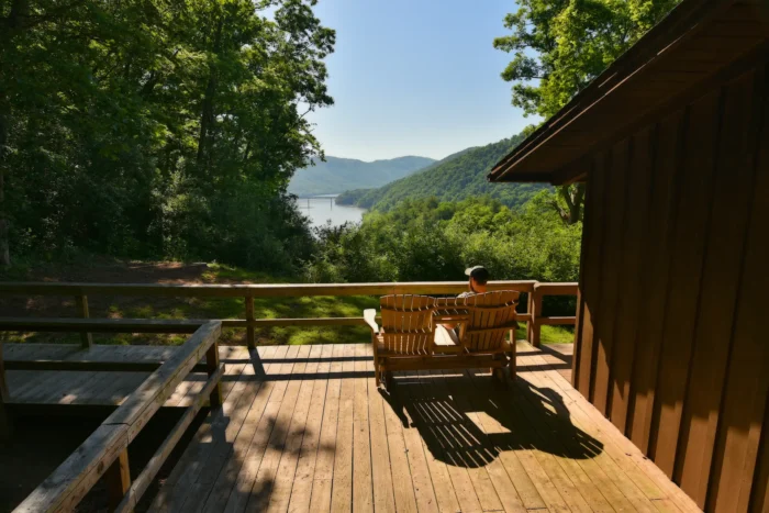 Man sitting on a deck enjoying the view of the lake at Bluestone State Park.
