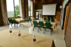 A conference or presentation room with tables and a projector at Hawks Nest State Park.