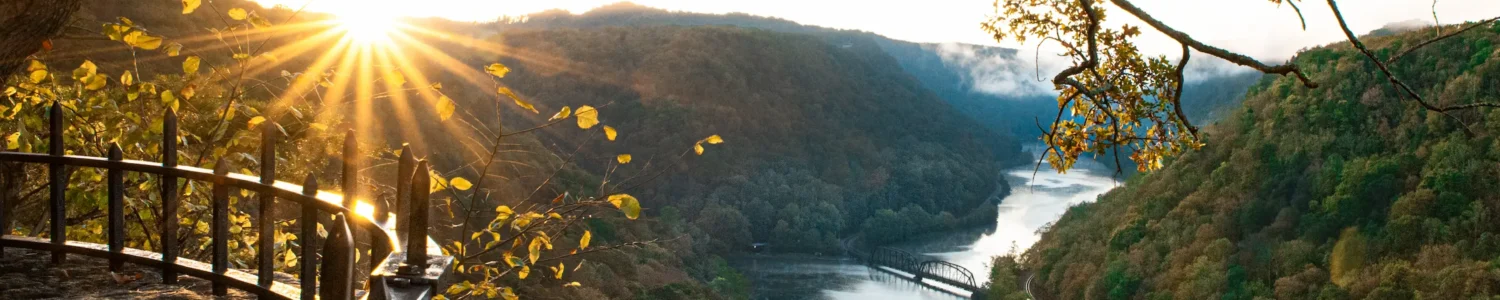 The evening sun peeks over the mountains at Hawks Nest State Park