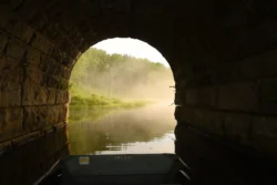 View from a boat floating inside a tunnel looking out to the lake.