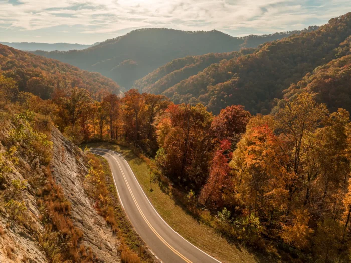 Aerial view of a road and surrounding mountains in Logan during the summer.