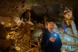 Young boy looking around to explore the Lost World Caverns and the various formations inside.