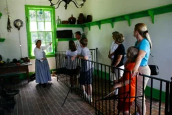 Tour guide showing a group of visitors pieces of history in the Blennerhassett Island mansion.