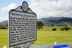 The archive sign with information on the birthplace of Pearl S. Buck and the Union campsite in the background.
