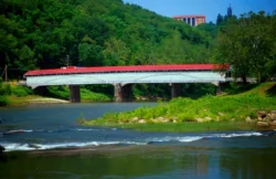Wide shot of the Philippi Covered Bridge crossing over Tygart River in Philippi, West Virginia.
