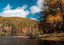 Lakeside point-of-view with a nearby dock and paddle boats in Watoga State Park during the fall.