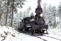Front view of steam locomotive traveling on a railroad during the winter.