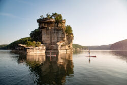 A paddleboarder on the serene water of Summersville Lake