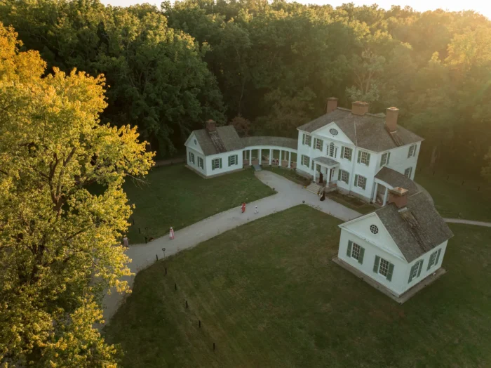 An aerial shot of the Blennerhassett mansion and surrounding grounds as the sun sets in the background