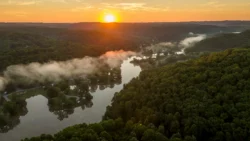 Aerial view of lake and forest at sunset with low fog at Beech Fork State Park