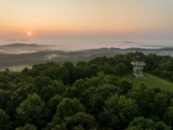 Sunrise over forested mountains at Pipestem Resort State Park with observation tower on hillside
