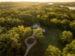 Aerial view of Blennerhassett Island Historical State Park mansion surrounded by forest and river at sunset