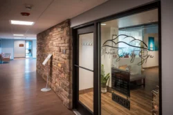 Mountain Serenity Spa entrance with glass door and posted hours sign