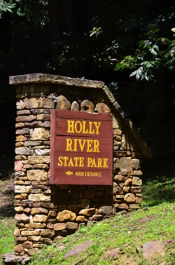 Holly River State Park entrance sign on stone base with main entrance direction